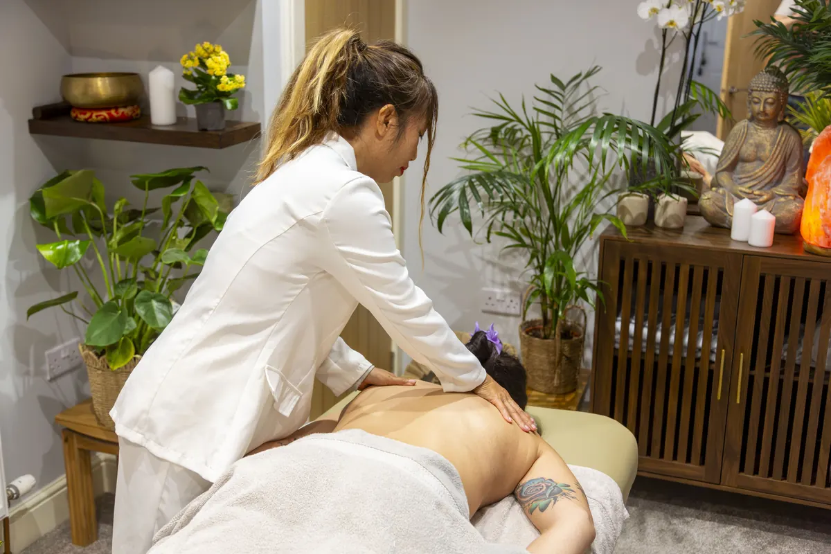 Nina giving a relaxing back massage surrounded by plants